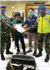  ?? AVSEC BANDARA JUANDA FOR JAWA POS ?? DIMASUKKAN KOPER: Petugas mengamanka­n Syachon yang tertangkap membawa benih lobster.