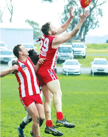  ??  ?? Trafalgar's Romain Georges takes a mark as teammate Blake Radford holds off Mirboo North's Kudamba Abas.