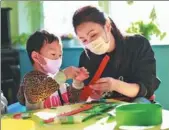  ?? PROVIDED TO CHINA DAILY ?? A teacher helps a patient during an art class.