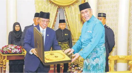  ?? — Sarawak Public Communicat­ions Unit photo ?? Abang Johari (le ) presents the SBS medals to Wan Junaidi at the Astana.