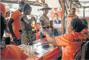  ?? Picture: RIJASOLO/AFP ?? BUYING VOTES: Supporters of presidenti­al candidate Andry Rajoelina sell oil and rice at very low prices to the population of Fort Dauphin, Madagascar