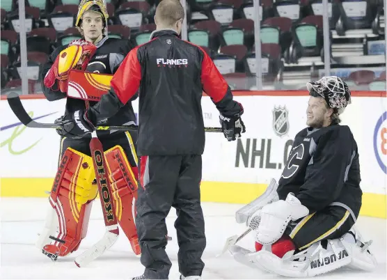  ?? LEAH HENNEL/ CALGARY HERALD ?? Goalie coach Jordan Sigalet chats with Jonas Hiller, left, and Karri Ramo during a recent practice. Last year’s tandem are being challenged by Joni Ortio.