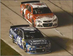  ?? Ralph Lauer/AP ?? Jimmie Johnson (48) beats Kevin Harvick (4) out of the pits during the NASCAR Sprint Cup series auto race at Texas Motor Speedway.