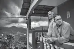  ?? Associated Press ?? ■ Marta Bermudez Robles and her husband, Juan Nunez, stand on the balcony of their home. After her power is restored, Bermudez said she planned to celebrate no longer having to eat a diet of mostly rice, bananas and soup, or wash clothes by hand in a...