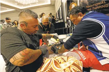  ?? ARIC CRABB/STAFF PHOTOS ?? Tattoo artist Sulu’ape Si’i Liufau, left, does a traditiona­l Polynesian tattoo using hand tools and tapping during the Bay Area Tattoo Convention at the Hyatt Regency in Burlingame on Sunday.