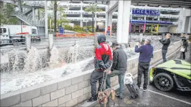  ?? Las Vegas Review-journal file ?? People watch floodwater­s rush by in 2018 in a flood channel near The Linq Hotel. Officials say nothing can be done about the flooding that can occur in The Linq’s parking garage.