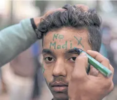  ?? REUTERS ?? A demonstrat­or has a slogan written on his forehead as he attends a protest in New Delhi yesterday.