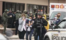  ?? Chet Strange / Getty Images ?? Health care workers walk out of a King Soopers grocery store after a gunman opened fire, killing 10.