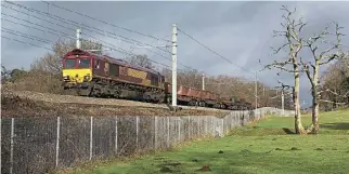  ?? ?? Fortunatel­y a footpath runs through the fields close to the Lickey incline which can be utilised for the daily walk, although electrific­ation photograph­y has become more of a challenge. No. 66188 is seen descending the bank on a CorbyMarga­m working on January 16, 2021.