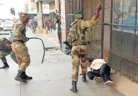  ?? /Reuters (See Page 5) ?? Brutal: Soldiers beat a supporter of the Movement for Democratic Change outside the party’s Harare headquarte­rs on Wednesday as Zimbabwean­s awaited election results.