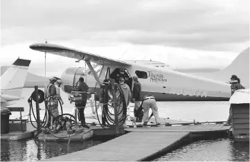  ??  ?? Guests and guides deplane at the lodge after a day of fishing. Nearly all the rivers that lodge guests’ fish are accessed by its three de Havilland Beaver and Cessna 206 floatplane­s.