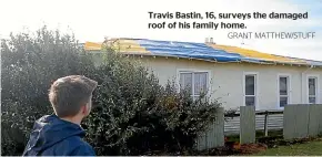  ?? GRANT MATTHEW/STUFF ?? Travis Bastin, 16, surveys the damaged roof of his family home.