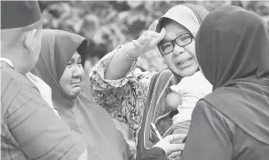  ?? — Gambar Bernama ?? SUASANA PILU: Zuhainum (dua kiri) ibu kepada Mohamad Haziq kelihatan sedih ketika menerima kunjungan saudara mara di rumah mereka di Kampung Leret A, Sedang di Bandar Baharu, semalam.