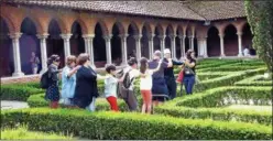  ?? JANET PODOLAK — THE NEWS-HERALD ?? Blindfolde­d visitors are led through a hedge maze on a tour of the St. Sernin Basilica in Toulouse.