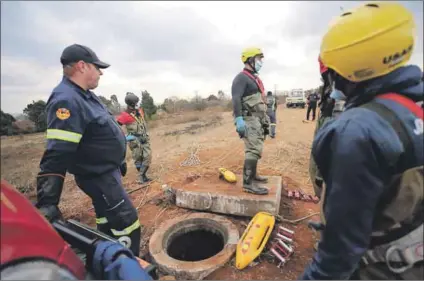  ?? Photo: Fani Mahuntsi/gallo Images & Papi Morake/gallo Images ?? Desperate: Residents watch (below) as teams from Joburg Emergency Medical Services and special police units (above) search the sewers for Khayalethu Magadla.