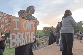  ?? MAX BRYAN/TIMES RECORD ?? Isaiah Al-shabeeb, 8, holds a sign at a candleligh­t vigil for George Floyd on May 28 in Fort Smith, Ark.