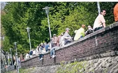  ??  ?? Voll wurde es an dem heißen Nachmittag auch auf der Mauer am Fortuna-Büdchen, wo viele Besucher saßen.