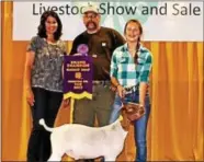  ??  ?? The Champion Market Goat was shown by Lily Bramm of Pottstown and was purchased by the B&R Excavating in Nottingham for $2.75/lb. David and Tiffany Bell owners of B&R Excavating of Nottingham are pictured with Lily.