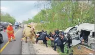  ?? ?? Policías y bomberos rescatan los cuerpos de una familia accidentad­a en una camioneta que volcó ayer en la autopista Mérida-Cancún