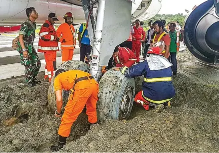  ?? POLDA PAPUA BARAT FOR RADAR SORONG/JPG ?? EVAKUASI: Petugas berusaha mengeluark­an roda pesawat Batik Air yang tergelinci­r di ujung landasan pacu Bandara Rendani Manokwari, Papua Barat, kemarin.
