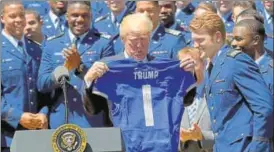  ?? AP ?? Donald Trump holds up an Air Force Academy football jersey presented to him by during a presentati­on ceremony of the Commanderi­nChief trophy on Tuesday at the White House.