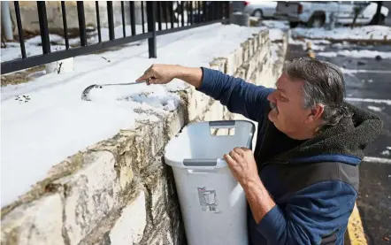  ?? — AFP ?? Wet days, dry taps: A resident scraping snow into a bucket to melt it into water in Austin, Texas.