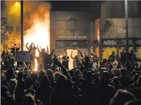  ?? Carlos Gonzalez The Associated Press ?? Cheering protesters watch the Minneapoli­s police’s 3rd Precinct building burn Thursday. The police had evacuated the building during protests over the in-custody death of George Floyd.