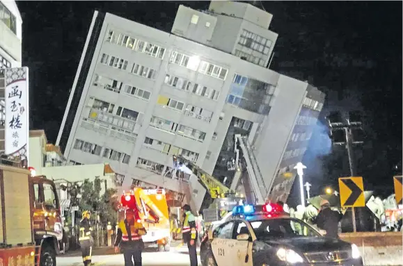  ?? Photo: AP ?? Rescuers are seen entering a building that collapsed onto its side from an early morning 6.4 magnitude earthquake in Hualien County, eastern Taiwan on Wednesday, February 7, 2018.