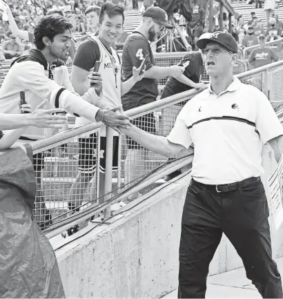  ?? JEFF HANISCH/USA TODAY SPORTS ?? Michigan head coach Jim Harbaugh greets fans prior to the Wolverines’ fifth win of 2021, against Wisconsin.