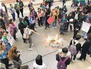  ?? EDUARDO CONTRERAS U-T ?? Women protesting murder and violence against women in Mexico burned their signs after marching from Tijuana to the San Ysidro Port of Entry on Friday.