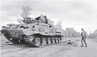  ?? Ap/mstyslav Chernov ?? Ukrainian serviceman walks past a blown russian APC near kutuzivka, north of kharkiv, east Ukraine on Sunday, May 15, 2022.