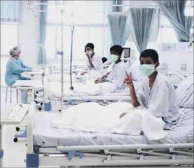  ??  ?? Three of the 12 boys recovering in their beds at Chiang Rai Prachanukr­oh Hospital in Thailand.