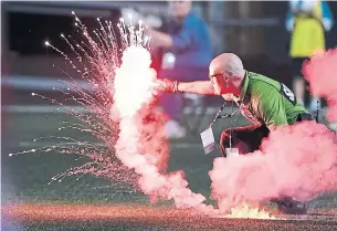  ?? JUSTIN TANG/THE CANADIAN PRESS ?? A flare thrown onto the field during the second half in Ottawa was retrieved by a security guard.