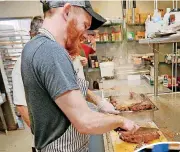  ?? [PHOTOS BY NATE BILLINGS, THE OKLAHOMAN] ?? ABOVE: Shane Roel, sous chef at The Hutch, slices ribs while cooking lunch at the Homeless Alliance’s WestTown shelter in Oklahoma City.
RIGHT: Juan Espinoza eats lunch Nov. 1 prepared by volunteers from The Hutch at the Homeless Alliance’s WestTown...