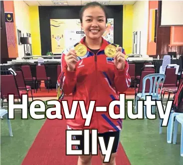  ??  ?? She’s tough: Sabah weightlift­er Elly Cascandra Engelbert posing with her gold medals.