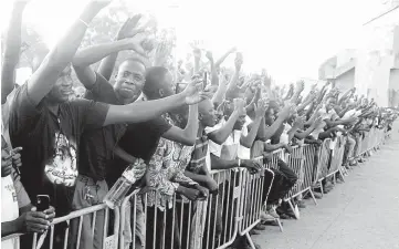  ??  ?? People cheer up Zida during a signature of a transition charter at the Maison du Peuple in Ouagadougo­u. — AFP photo