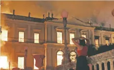  ??  ?? Una mujer observa el incendio en el Museo Nacional de Brasil.