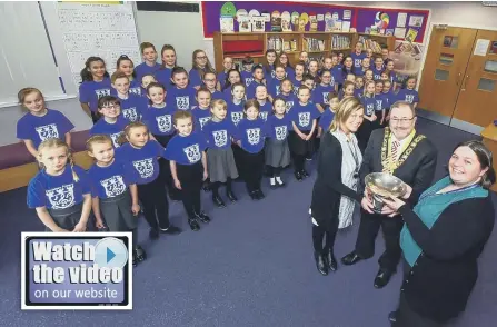  ??  ?? The Mayor of Sunderland, Coun Alan Emerson, presenting the Dr. Gilbert Trophy to the City Sings winners, Castletown Primary School, received by Gwen Ebdon, assistant, Caoimhe Nichomhrai, choir director, and headteache­r Joan Lumsdon, right.