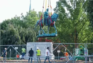  ?? (Evelyn Hockstein/Reuters) ?? A STATUE OF Confederat­e Gen. Robert E. Lee is removed after a years-long legal battle over the contentiou­s monument in Charlottes­ville, Virginia yesterday.