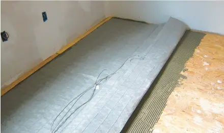  ?? TIM CARTER ?? This fabric mat contains electric heating cables. Finished flooring is installed on top of the mat after it’s covered with a thin coat of sand and cement.