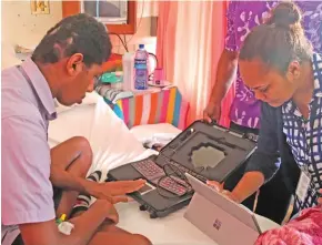  ??  ?? A Department of Immigratio­n staff member assisting Ratu Drugucava Manoa Bosevakatu­raga with his e-passport applicatio­n from his hospital bed.