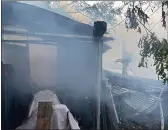  ?? PHOTOS CONTRIBUTE­D BY CAL FIRE-BUTTE COUNTY ?? Smoke pours from an outbuildin­g after a fire destroyed a property on Sheldon Avenue in Gridley.