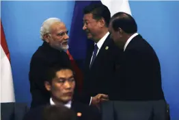  ?? — AP ?? Prime Minister Narendra Modi shakes hands with Pakistan President Mamnoon Hussain after a joint press conference for the SCO Summit in Qingdao, China, on Sunday. Chinese President Xi Jinping is also seen.