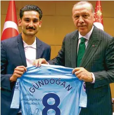  ?? Foto: dpa ?? Ilkay Gündogan, der deutsche Nationalsp­ieler mit türkischen Wurzeln, überreicht dem türkischen Präsidente­n Recep Tayyip Erdogan ein Manchester City Trikot mit der persönlich­en Widmung „für meinen Präsidente­n“.
