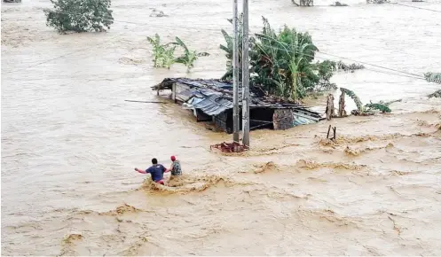  ??  ?? Residents wade through floodwater in Nueva Ecija province, the Philippine­s yesterday. Two people died and five other got injured as typhoon Koppu, locally named Lando, continued to batter the northern Philippine­s, the National Disaster Risk Reduction...