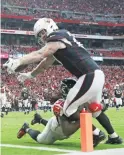  ??  ?? Cardinals tight end Maxx Williams reaches to score a touchdown while tackled by the Falcons’ Kemal Ishmael on Sunday.