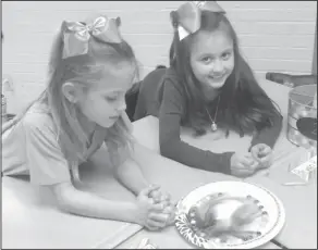  ??  ?? Note: Northwest Elementary second graders Marleigh Murphy and Gracen Darden conduct an experiment using Skittles and water.