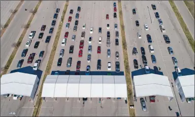  ?? (AP/Austin American-Statesman/Jay Janner) ?? Motorists line up for covid-19 vaccines Saturday at Circuit of the Americas in Austin, Texas. Travis, Hays, Caldwell and Bastrop counties collaborat­ed on the event with a goal of vaccinatin­g 10,000 people over the weekend.