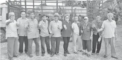  ??  ?? SEMPENA AIDILADHA: Ling (berdiri lima kanan) menyerahka­n lembu kepada penduduk di kawasan DUN Simanggang semalam.