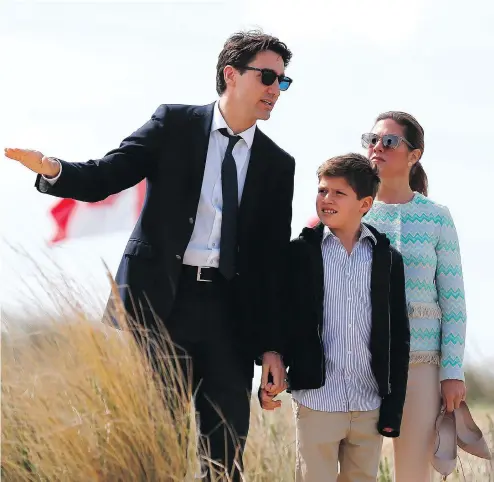  ?? CHARLY TRIBALLEAU/AFP/GETTY IMAGES ?? Prime Minister Justin Trudeau, his wife, Sophie Gregoire, and their son, Xavier, walk along Juno Beach on Monday in France. When asked whether he feared the world was on the verge of a new war, Trudeau said the internatio­nal community needed to come...